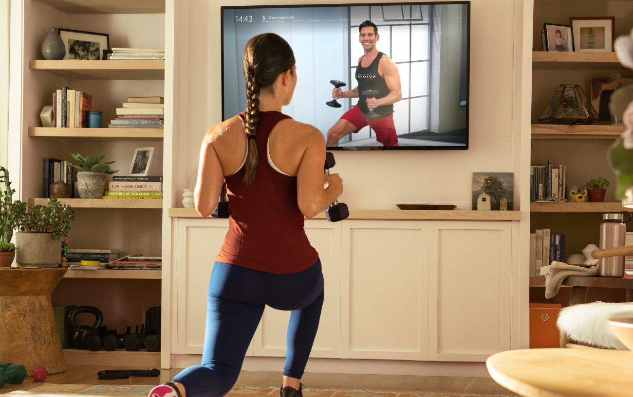 A woman tries one of the best Peloton classes for weight loss in her living room.